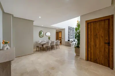 a dining room with a table and chairs and a door at L'Elara - Semlalia - Duplex - Piscine in Marrakech