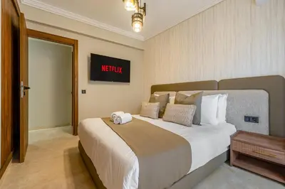 a bedroom with a large white bed with a sign on the wall at L'Elara - Semlalia - Duplex - Piscine in Marrakech