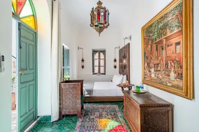a bedroom with a bed and a painting on the wall at Riad Dar Amani in Marrakech