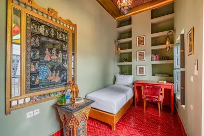 a bedroom with a bed and a table and a desk at Riad Dar Amani in Marrakech