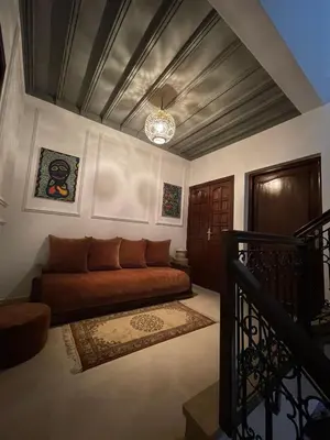 a living room with a brown couch in a room at Dar Diaft'na in Marrakech