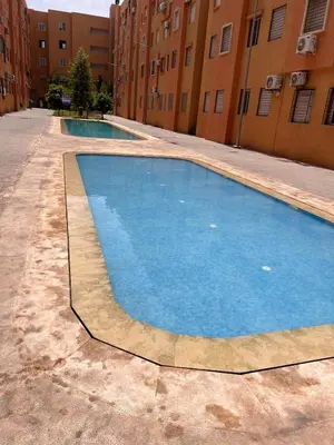 an empty swimming pool in front of some buildings at New, quiet and comfortable in Marrakech