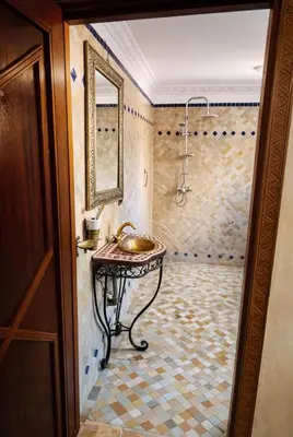a bathroom with a sink and a shower with a mirror at Très bel Riad avec piscine au cœur de Marrakech in Marrakech
