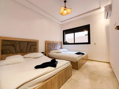 a bedroom with two beds and a window at Elegant 3-Bedroom Duplex Downtown Private Terrace in Marrakech