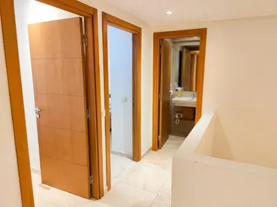a bathroom with a toilet and a sink and a door at Elegant 3-Bedroom Duplex Downtown Private Terrace in Marrakech
