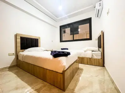 a bedroom with two beds and a mirror on the wall at Elegant 3-Bedroom Duplex Downtown Private Terrace in Marrakech