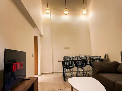 a living room with a table with chairs and a couch at Elegant 3-Bedroom Duplex Downtown Private Terrace in Marrakech