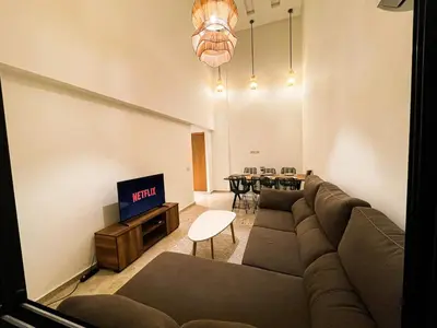 a living room with a couch and a tv at Elegant 3-Bedroom Duplex Downtown Private Terrace in Marrakech