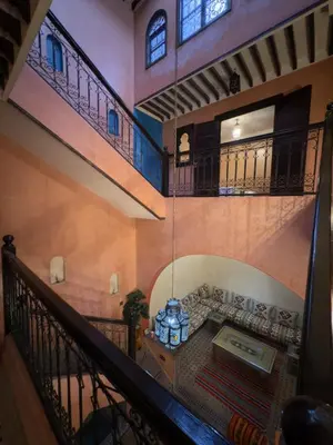 a living room with a couch and a table in a building at Authentic Moroccan Riad with a pool and a rooftop in Marrakech