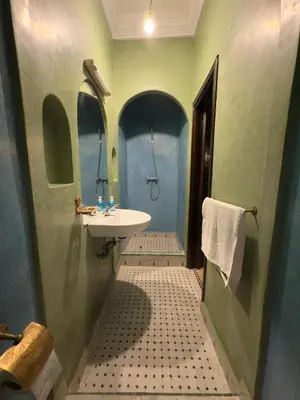 a small bathroom with a sink and a toilet at Authentic Moroccan Riad with a pool and a rooftop in Marrakech