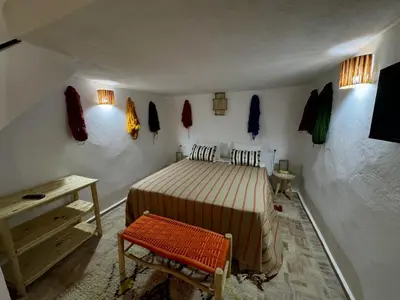 a bedroom with a bed and a table and a bench at Riad Dar Familya in Marrakech