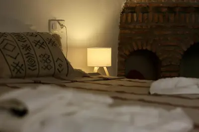 a bed with a lamp next to a brick fireplace at Riad Dar Familya in Marrakech