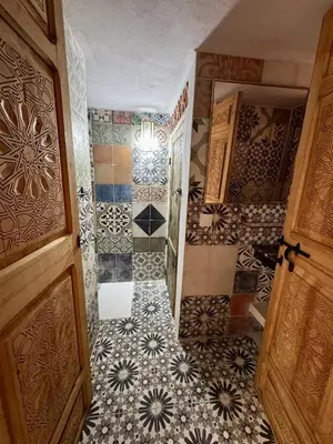 a bathroom with a tiled floor and a door at Riad Dar Familya in Marrakech