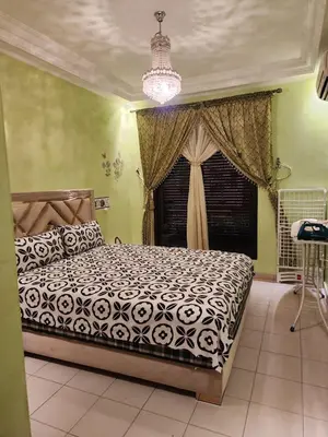 a bedroom with a bed and a chandelier at Comfortable apartment for families in Marrakech