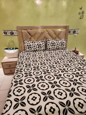 a bedroom with a bed with a black and white bedspread at Comfortable apartment for families in Marrakech