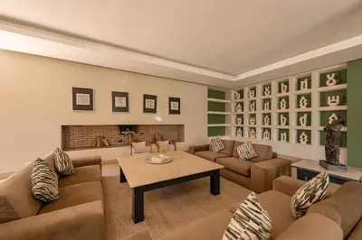 a living room with couches and a fireplace at 2 Superbe villas avec chacune piscine privée & jardin 5 ou 6 chambres in Marrakech