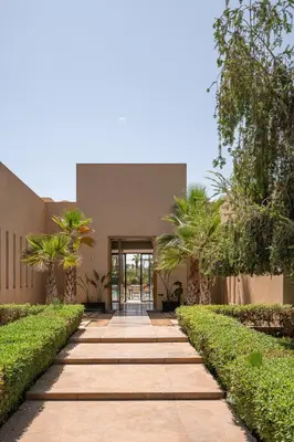 a walkway in front of a building with palm trees at 2 Superbe villas avec chacune piscine privée & jardin 5 ou 6 chambres in Marrakech