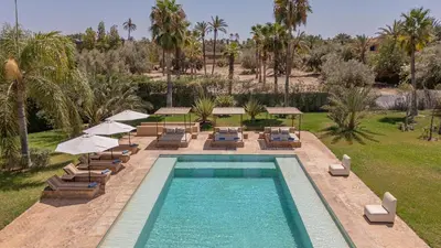 a swimming pool with lounge chairs and umbrellas at 2 Superbe villas avec chacune piscine privée & jardin 5 ou 6 chambres in Marrakech
