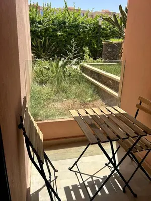 a wooden chair sitting on a porch looking out a window at New! Nouveau! Le Cocon familial in Marrakech