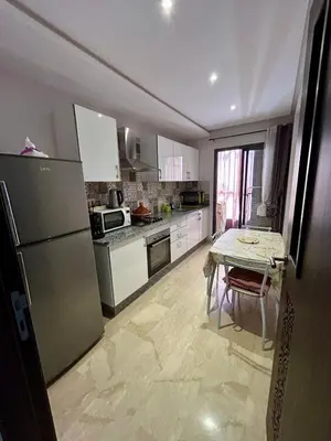 a kitchen with a table and a refrigerator at New! Nouveau! Le Cocon familial in Marrakech