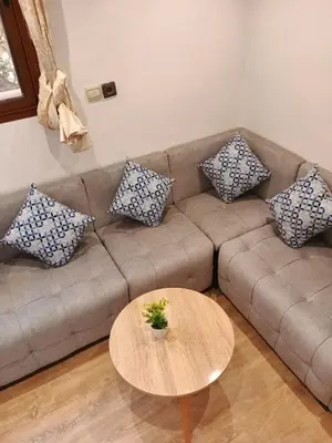 a living room with a couch with pillows and a table at Le Palmier de Guéliz in Marrakech
