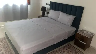 a bedroom with a large bed with a blue headboard at Beautiful, very quiet apartment in Marrakech