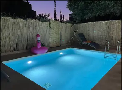 a swimming pool with a pink object next to a fence at Villa Dar Moumoune à Marrakech, piscine chauffée en option in Sraghna