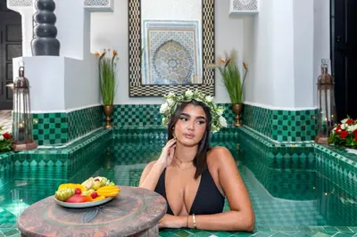 a woman sitting in a pool with a bowl of fruit at Dar Bonita in Marrakech
