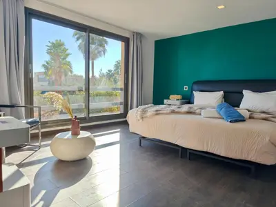 a bedroom with green walls and a bed with a large window at Duplex Premium 3 Suites, Style Villa, Terrasse & Accès direct piscine, Oliver Palm Resort Marrakech in Marrakech
