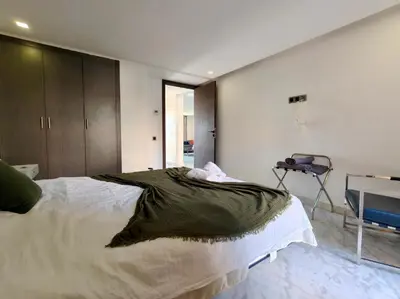 a bedroom with a large bed and a desk at Duplex Premium 3 Suites, Style Villa, Terrasse & Accès direct piscine, Oliver Palm Resort Marrakech in Marrakech