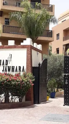 a gate in front of a building with a palm tree at Studio cosy Centre ville à 4 min et stade à 6 min in Marrakech