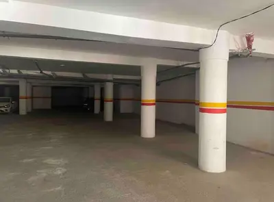 a parking garage with white columns with red and yellow stripes at Studio cosy Centre ville à 4 min et stade à 6 min in Marrakech