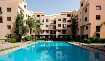 a swimming pool in front of a building at Studio cosy Centre ville à 4 min et stade à 6 min in Marrakech