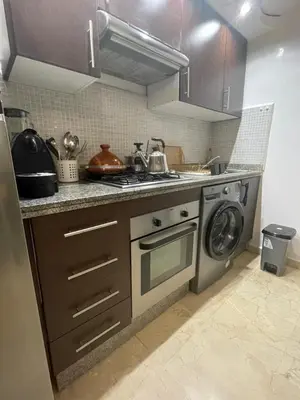 a kitchen with a stove and a washing machine at Studio cosy Centre ville à 4 min et stade à 6 min in Marrakech