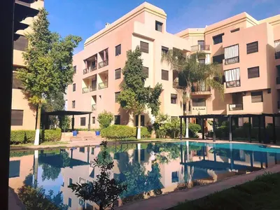 an apartment building with a pool in front of it at Studio cosy Centre ville à 4 min et stade à 6 min in Marrakech