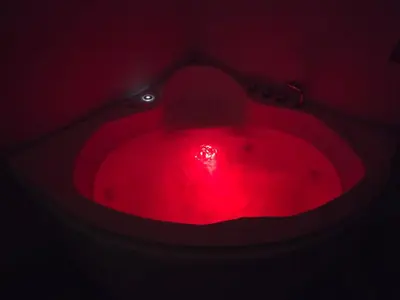 a red bath tub with a red light in a dark room at Villa targa prestige in Marrakech