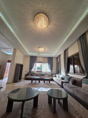 a living room with couches and tables and a chandelier at Villa targa prestige in Marrakech