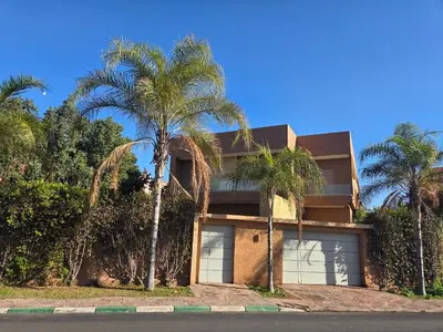 a house with palm trees in front of it at Villa targa prestige in Marrakech
