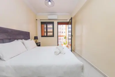 a white bed with a teddy bear sitting on it at Charming Majorelle Apartment in Marrakech
