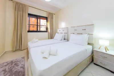 two beds in a room with a window at Charming Majorelle Apartment in Marrakech