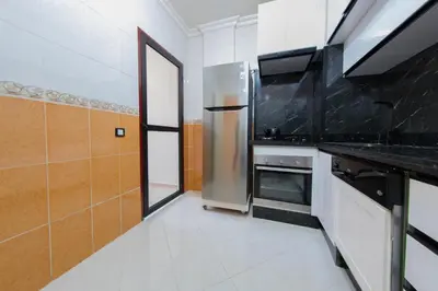 a kitchen with a stove and a refrigerator at Charming Majorelle Apartment in Marrakech