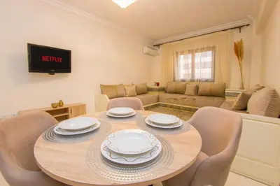 a dining room with a table and chairs and a couch at Charming Majorelle Apartment in Marrakech