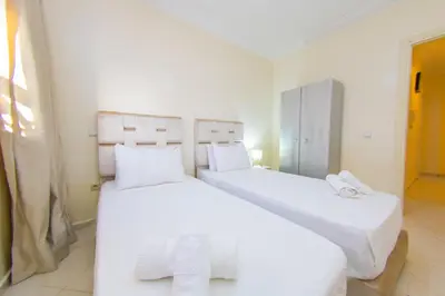 two beds in a room with white sheets and towels at Charming Majorelle Apartment in Marrakech