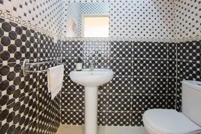 a bathroom with a sink and a toilet and a mirror at Charming Majorelle Apartment in Marrakech