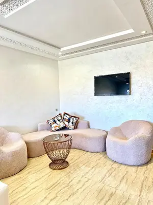 a living room with two couches and a flat screen tv at Séjournez dans un appart moderne, calme et tout équipé à Marrakech in Marrakech