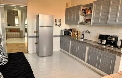 a kitchen with a stainless steel refrigerator and cabinets at Hide & seek in Marrakech