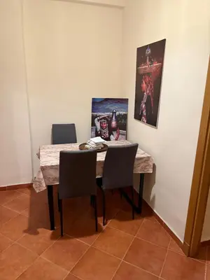a dining room table with two chairs and a painting at The cozy Den in Marrakech
