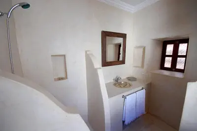 a white bathroom with a sink and a mirror at Riad Porte Royale in Marrakech
