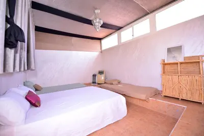 a bedroom with a large white bed and a window at Le riad de Daba in Marrakech