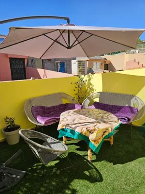 a table and chairs and an umbrella on a patio at Le riad de Daba in Marrakech